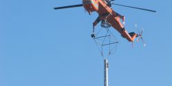 Assembly of a steel tube tower with helicopter